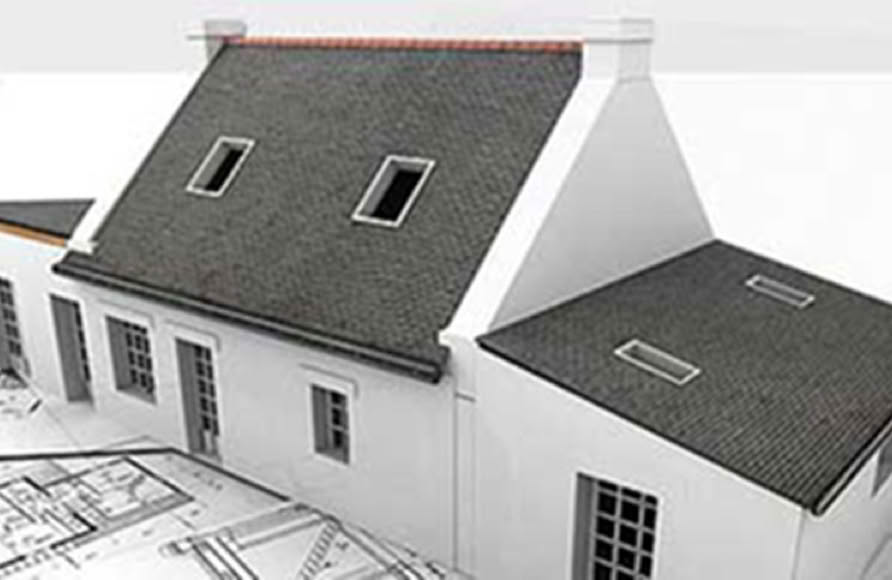 A white house model with a dark roof is placed on architectural blueprints.